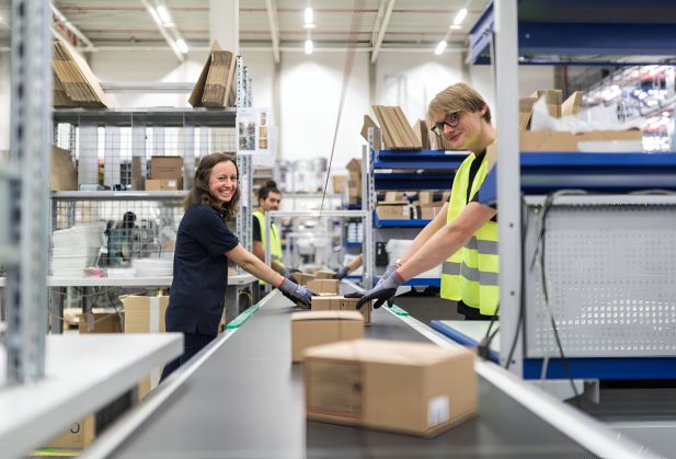 Workers working on conveyor belt in warehouse